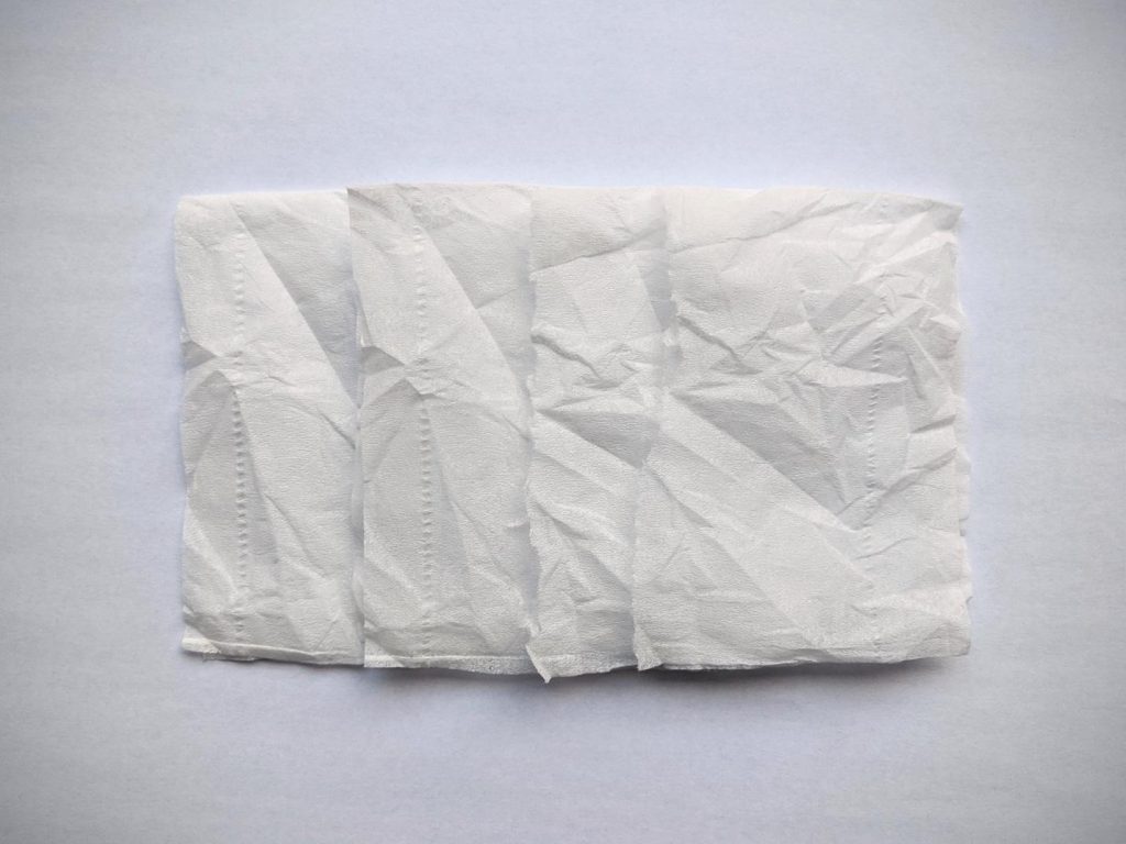 Four overlapping sheets of crinkled, thin ply paper.