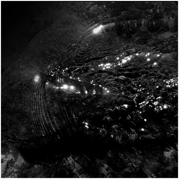 A black-and-white photo of ripples on the surface of water.