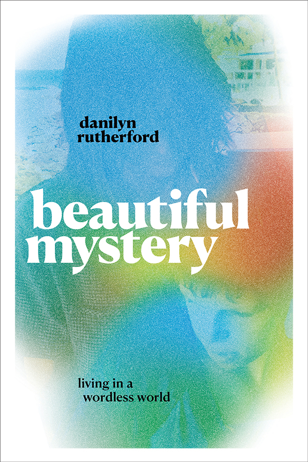 The cover of Danilyn Rutherford's book. The words "beautiful mystery: living in a wordless world" are in white against a pixelated, rainbow background. The outline of a child's face is faintly visible in the colors.