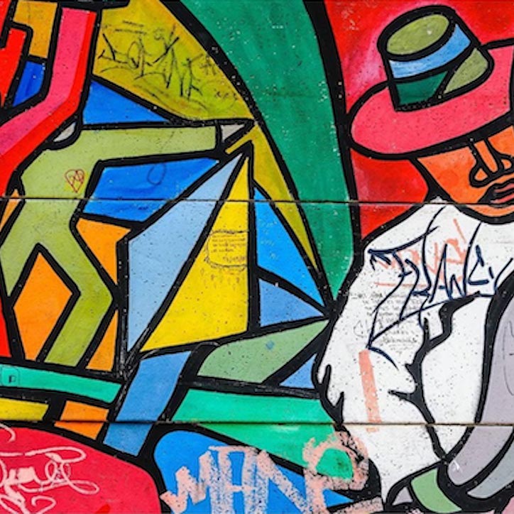 An abstract artwork with bright primary and secondary colors, representing a man in a hat holding tools amid a mosaic background depicting human figures and other shapes.