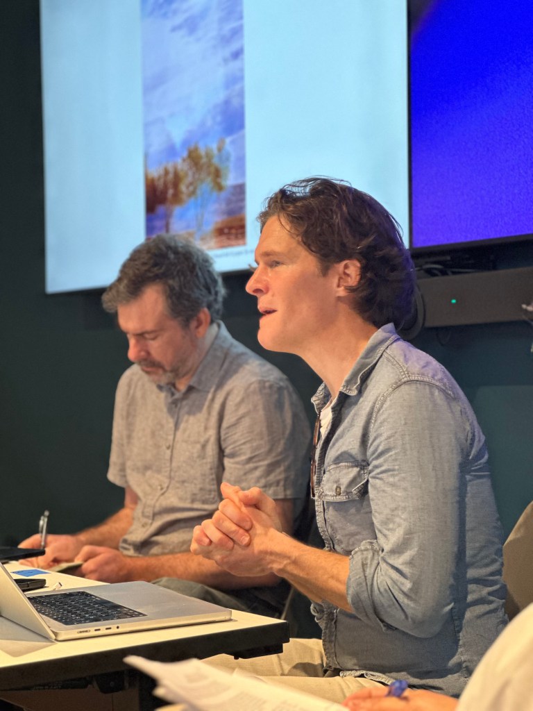 Jamie Cross sits in front of a screen and talks.