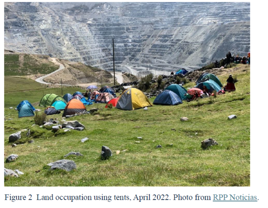 Tents on a grassy hillside in front of a terraced valley. The caption reads, "Figure 2: Land occupation using tents, April 2022. Photo from RPP Noticias."