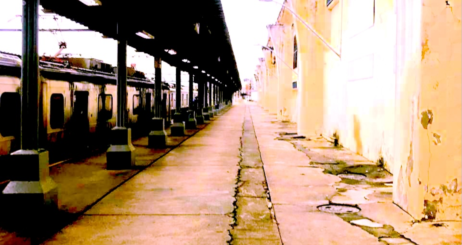 A train platform with a passing train.