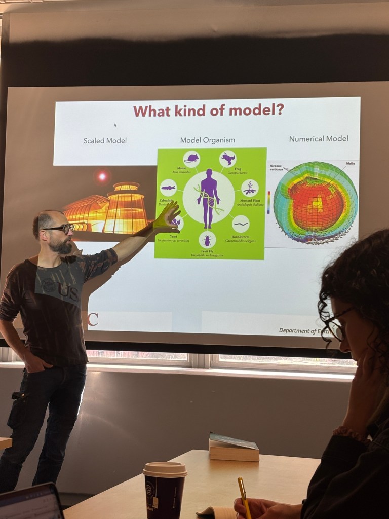 Julien Emile-Geay pointing to three types of models projected on the screen